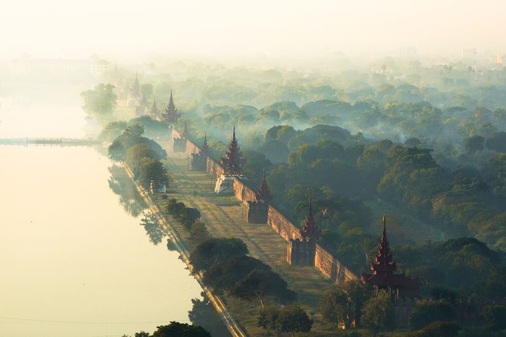 an aerial view of a city with lots of trees and buildings on the other side