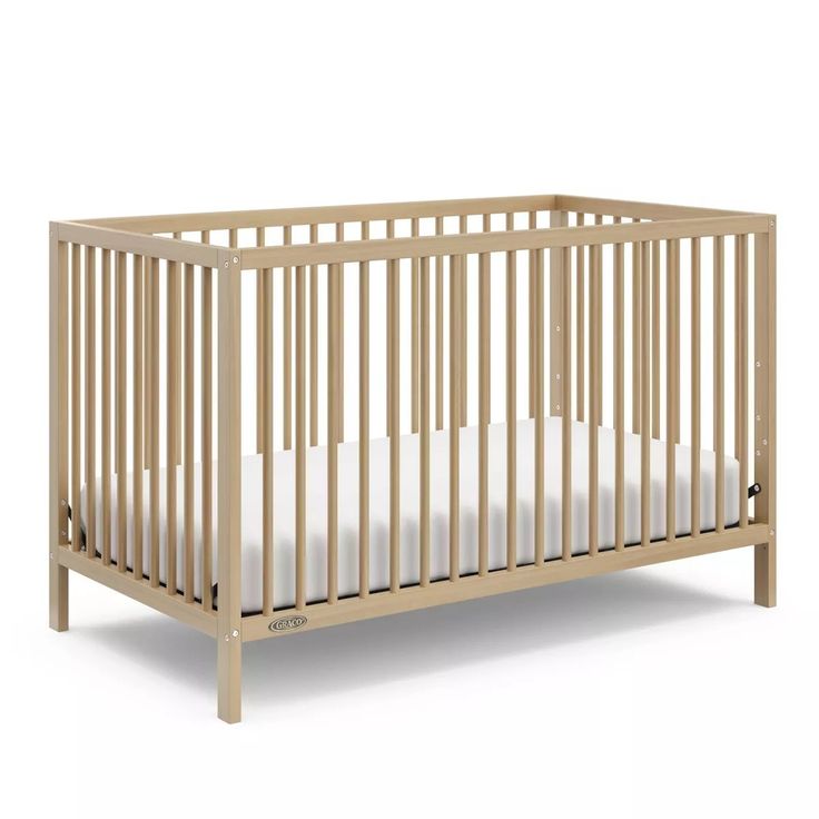 a wooden crib with white sheets on the bottom and side rails, against a white background