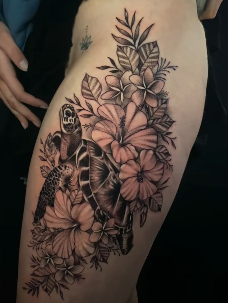 a woman's thigh with flowers and a turtle on it