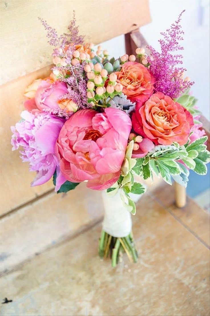 a bouquet of flowers sitting on top of a wooden chair