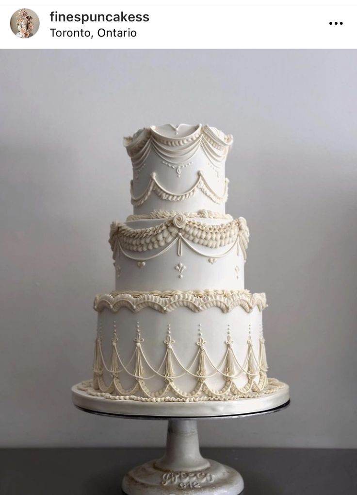 a three tiered white wedding cake sitting on top of a table