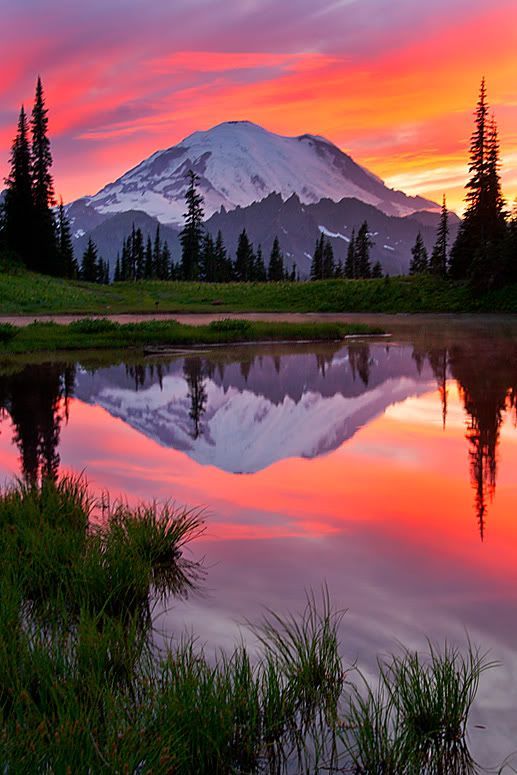 a mountain is reflected in the water at sunset