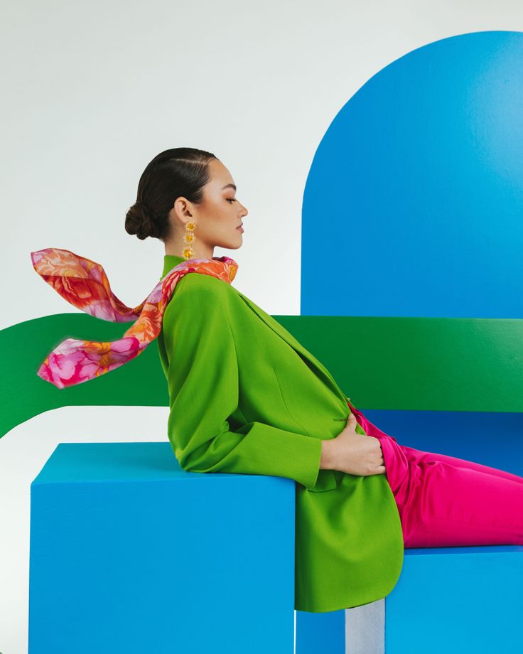 a woman sitting on top of a blue and green bench