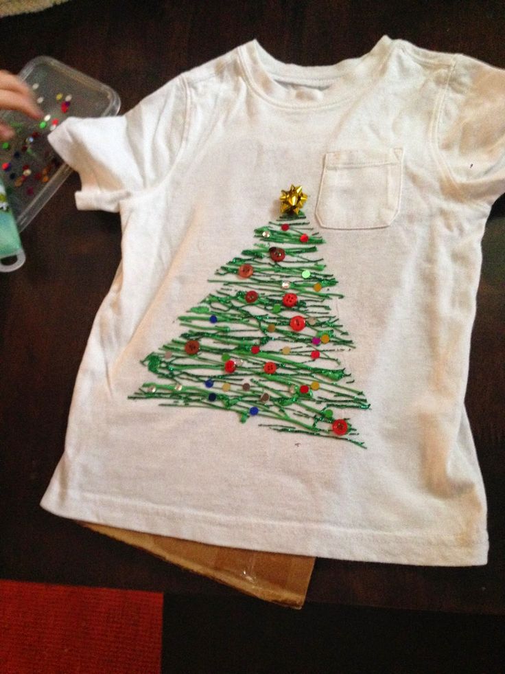 a child's t - shirt with a christmas tree on it and a pair of scissors