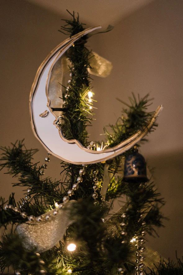 a christmas tree with a crescent ornament hanging from it