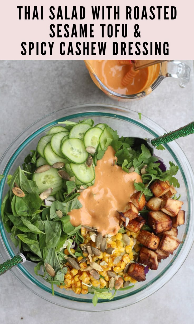 a salad with roasted sesame tofu and spicy cashew dressing in a glass bowl