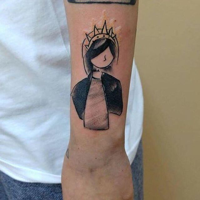 a small tattoo on the arm of a person wearing a crown and holding a cross