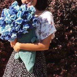 a woman holding a bouquet of blue flowers