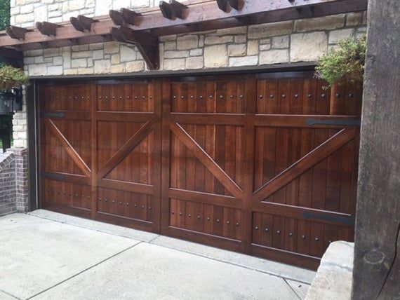 a wooden garage door is shown in front of a brick building