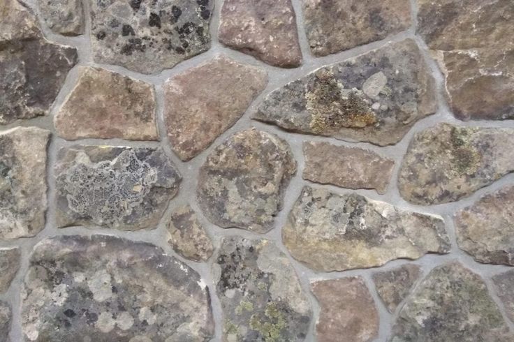 a stone wall that is made out of various types of rocks