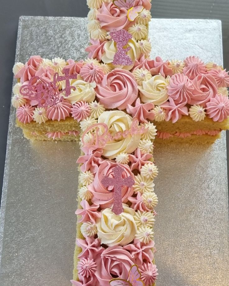 a cake decorated with pink and white frosting in the shape of a cross