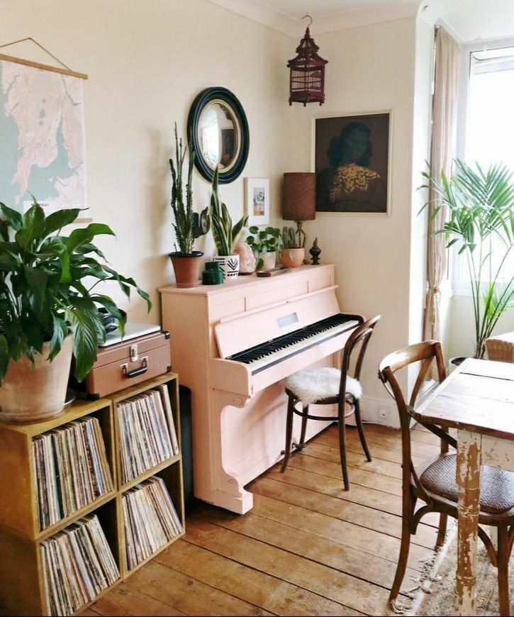 a living room filled with furniture and a pink piano in front of a large window