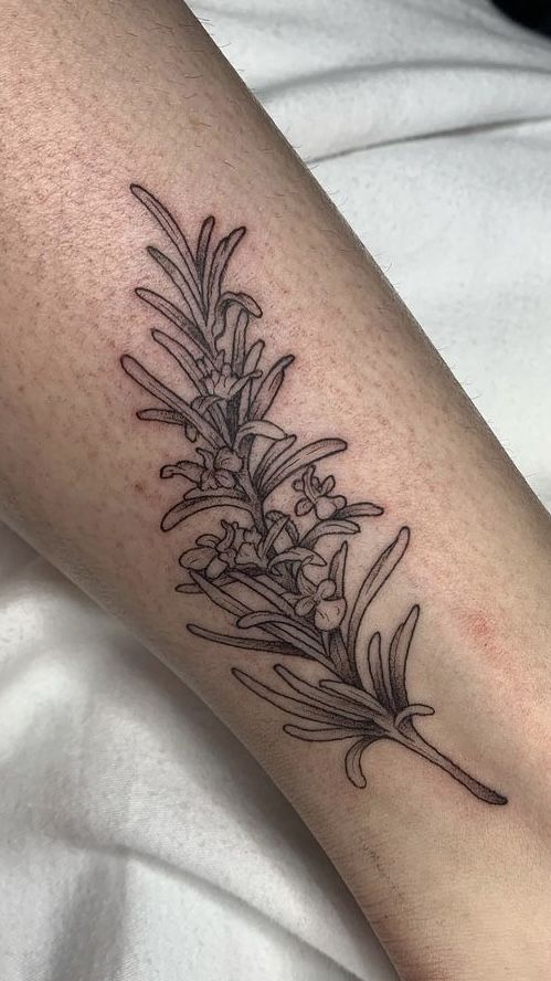 a black and white photo of a flower tattoo on the leg