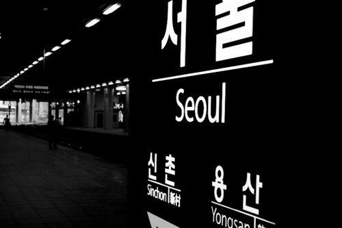 a black and white photo of a train station with the word seoul written in chinese