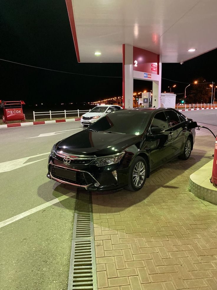 a black car is parked at a gas station