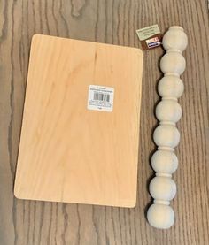 a wooden cutting board next to some white balls on a table with a price tag