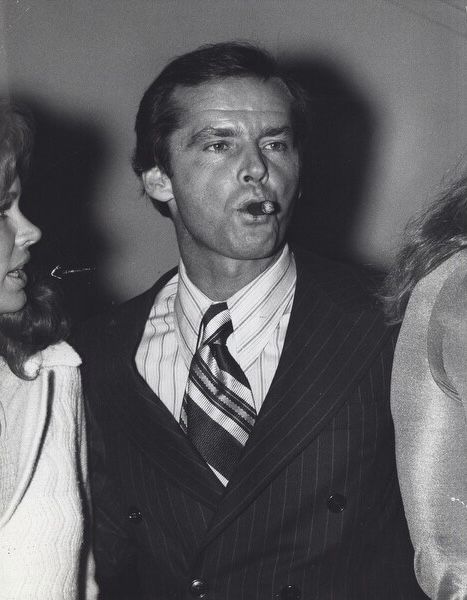 a man in a suit and tie standing next to two women