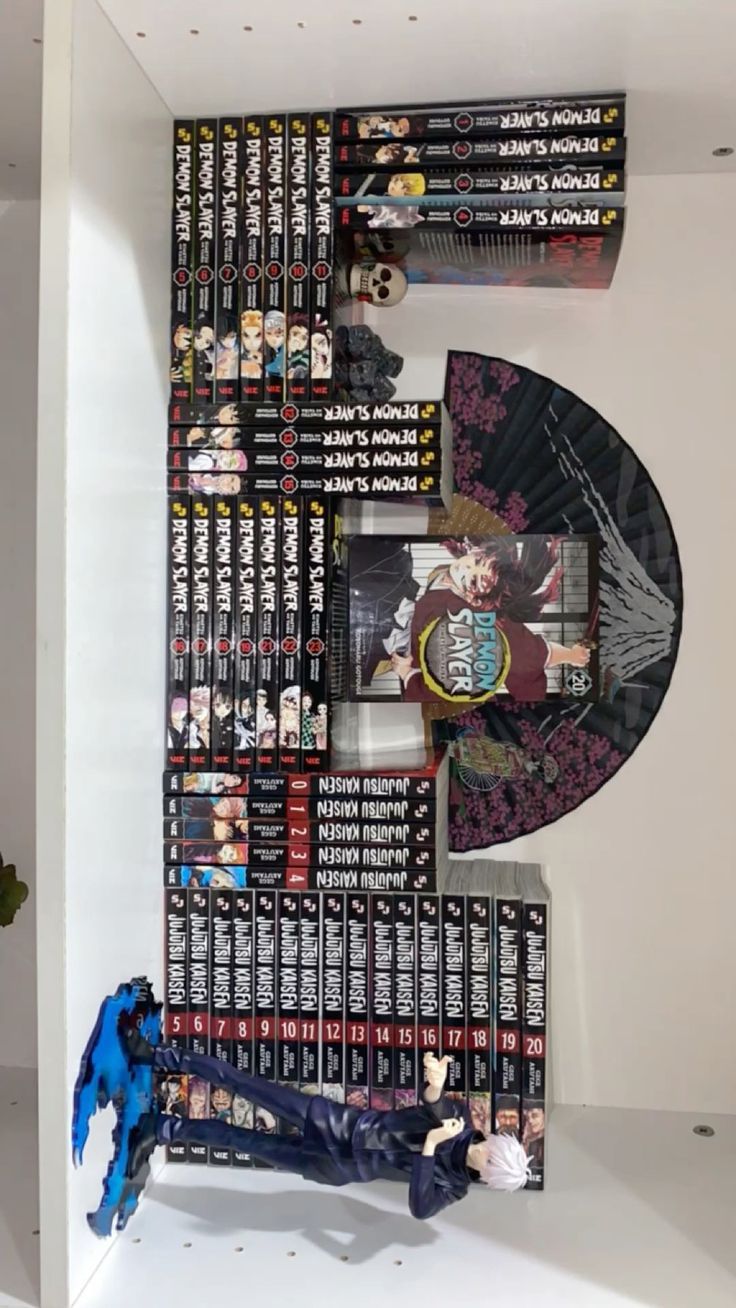 a shelf filled with lots of dvd's on top of each other in front of a white wall