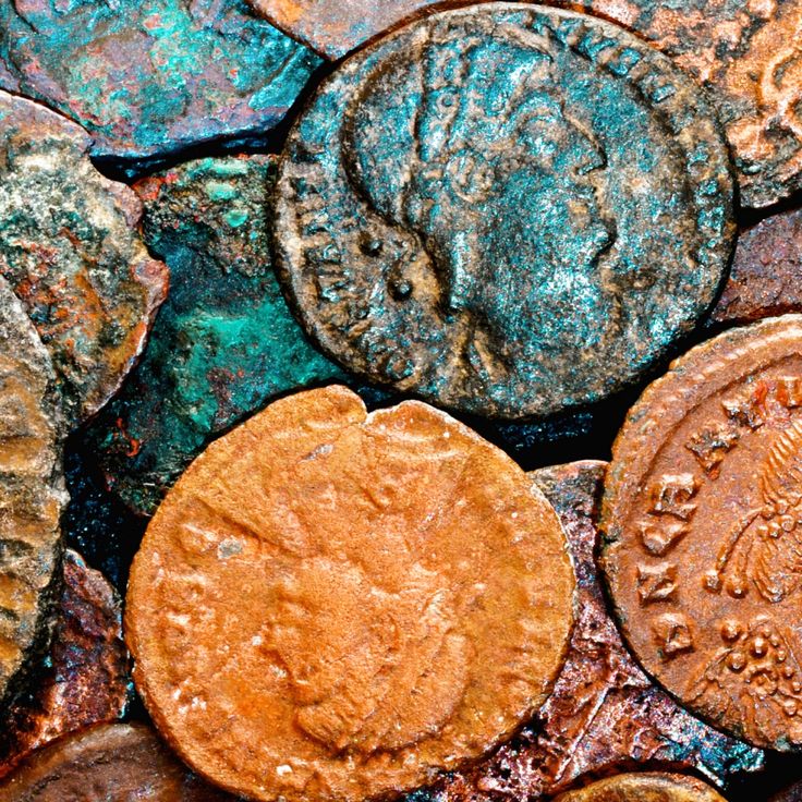 some old coins are laying on top of each other in a pile with rusted paint