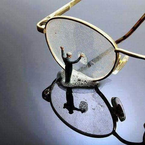 a man standing on top of a pair of glasses