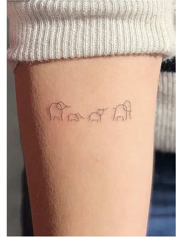 three elephants tattoo on the left side of the calf's leg, which is written in cursive writing