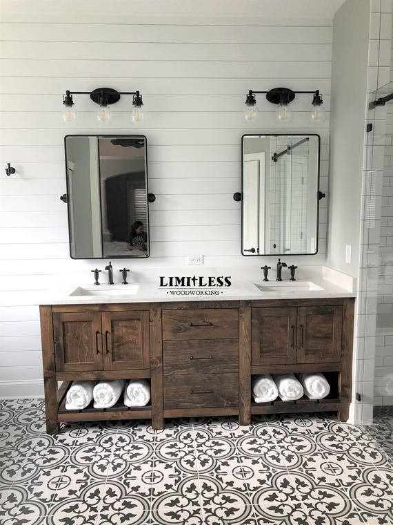 a bathroom with two sinks and mirrors on the wall above them is decorated in black and white tile