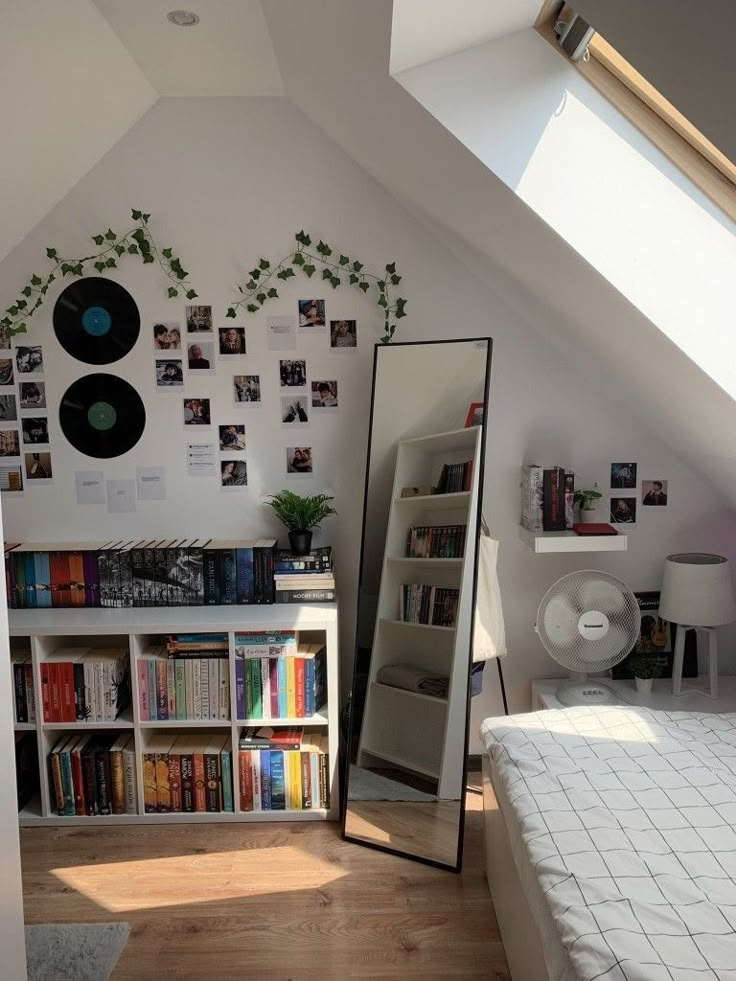 a room with a bed, bookshelf and pictures on the wall