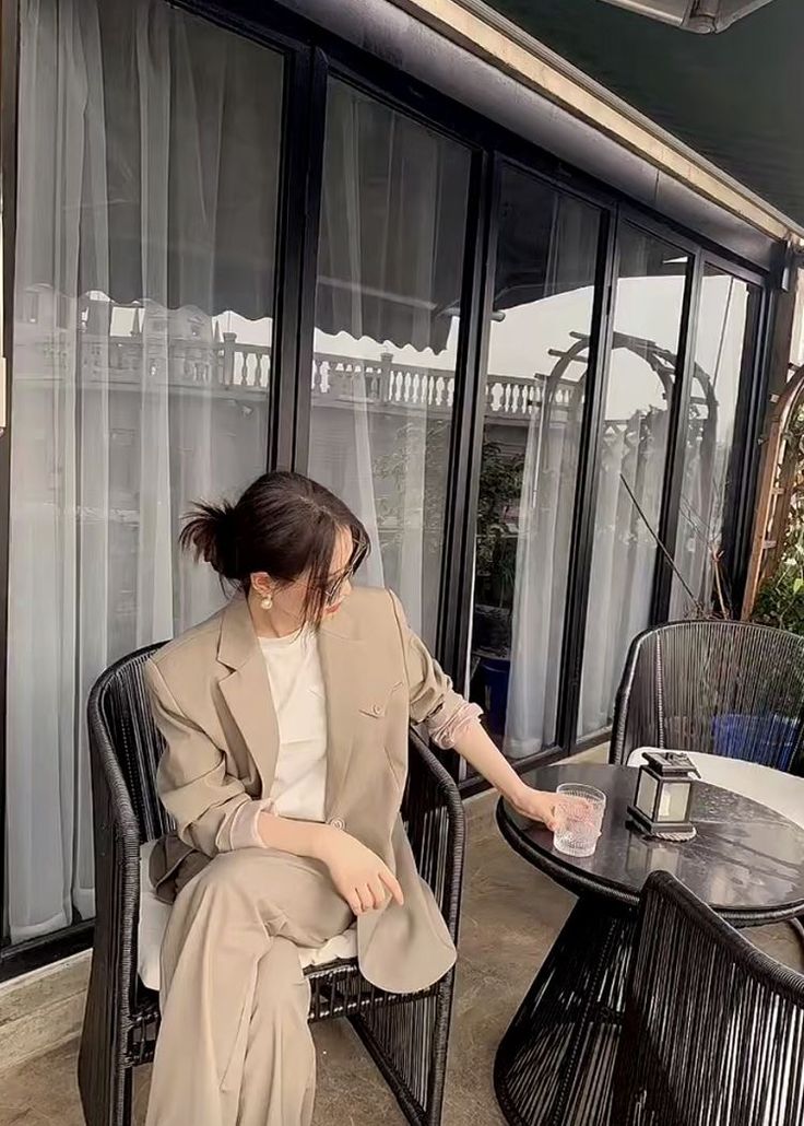 a woman sitting in a chair next to a table