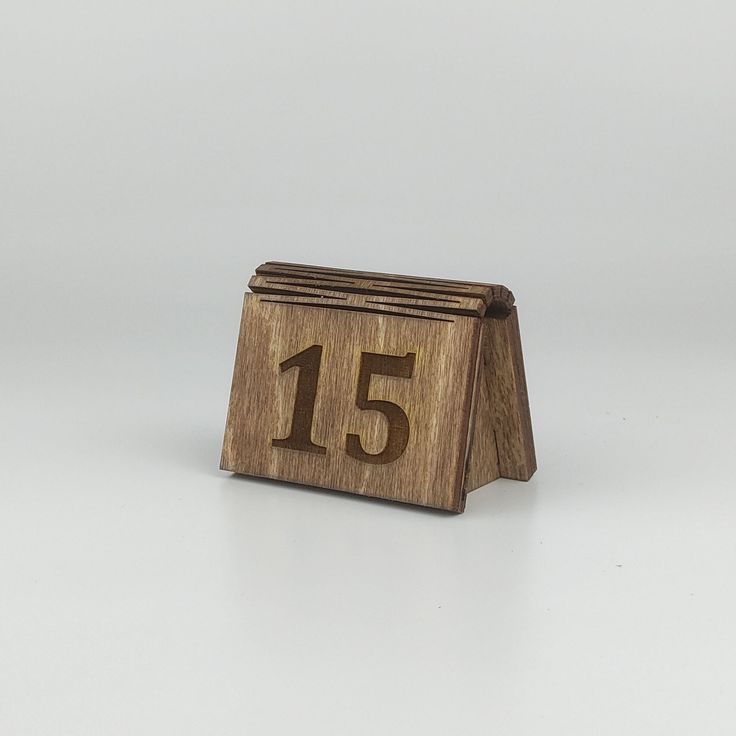 a small wooden block with the number fifteen on it's front and back sides