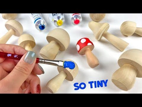 someone is painting wooden toys with markers and glues on the top of each mushroom