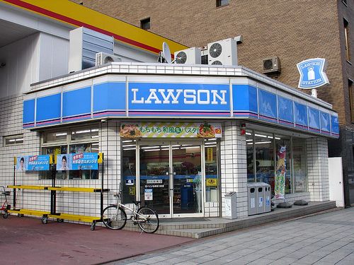 a bike is parked in front of a lawson store on the corner of a city street