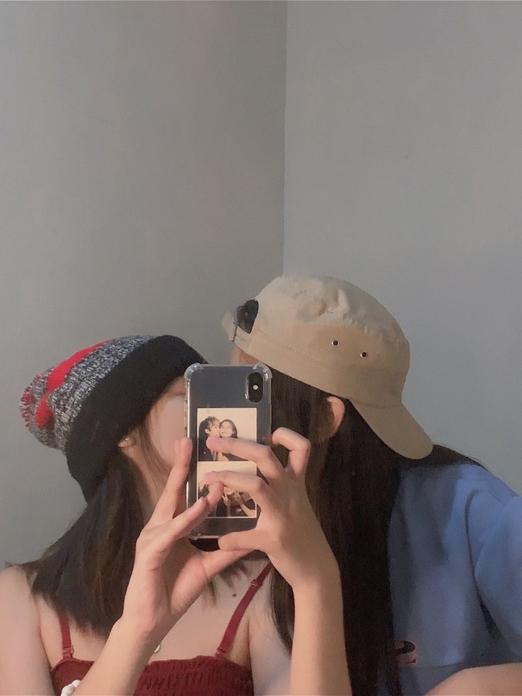 two people taking pictures with their cell phones