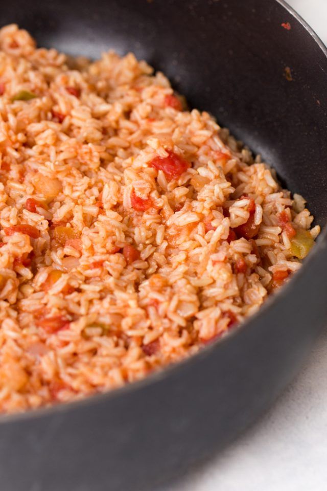 a pan filled with rice and vegetables on top of a stove