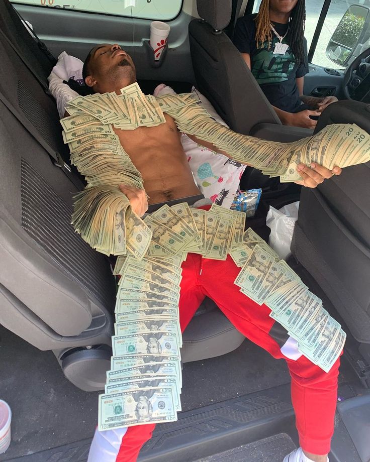 a man is sleeping in the back seat of a car with money wrapped around his body