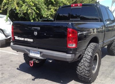 the back end of a black truck parked in a parking lot