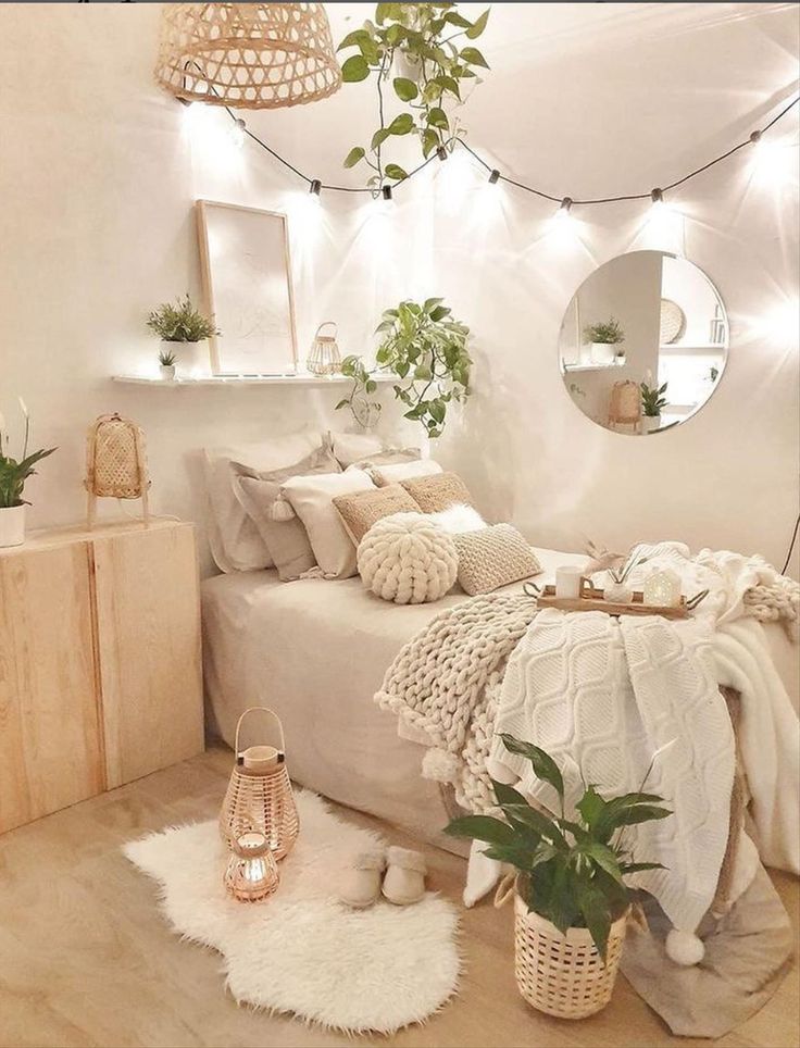 a bedroom with white walls and wooden flooring, plants in baskets on the bed