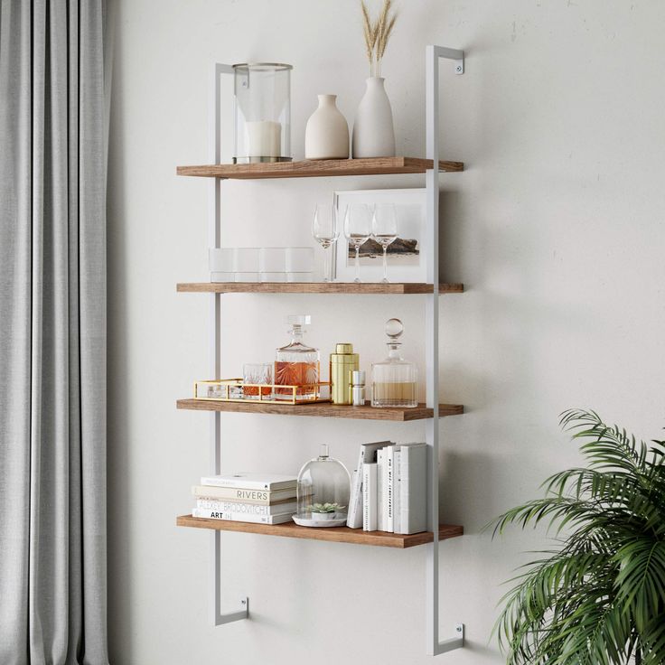 three wooden shelves with books and vases on them in the corner of a room