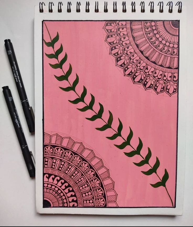 a pink notebook with some black markers on it