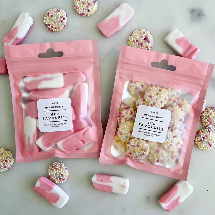 two bags of pink and white candy with sprinkles on the top one is filled with marshmallows