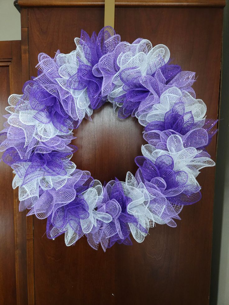 a purple and white mesh wreath on a wooden door