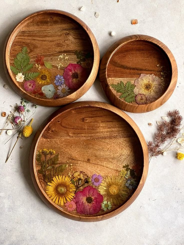 three wooden bowls with flowers painted on them