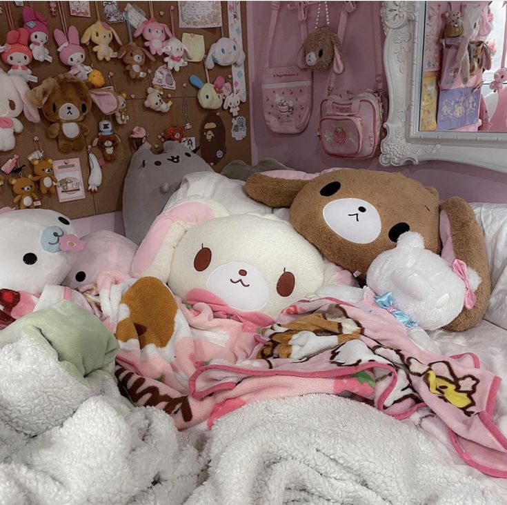 several stuffed animals laying on top of a bed in a room filled with pink walls