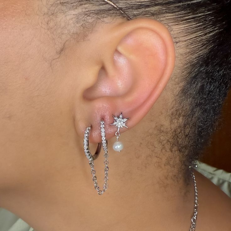 a close up of a person's ear with some piercings on top of it