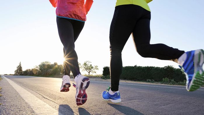 two women running down the road in bright colored clothes and sneakers, both wearing colorful shoes