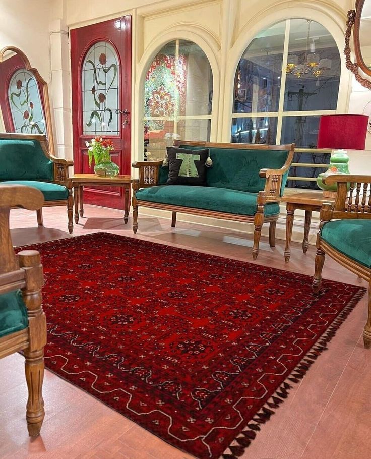 a living room filled with furniture and a red rug