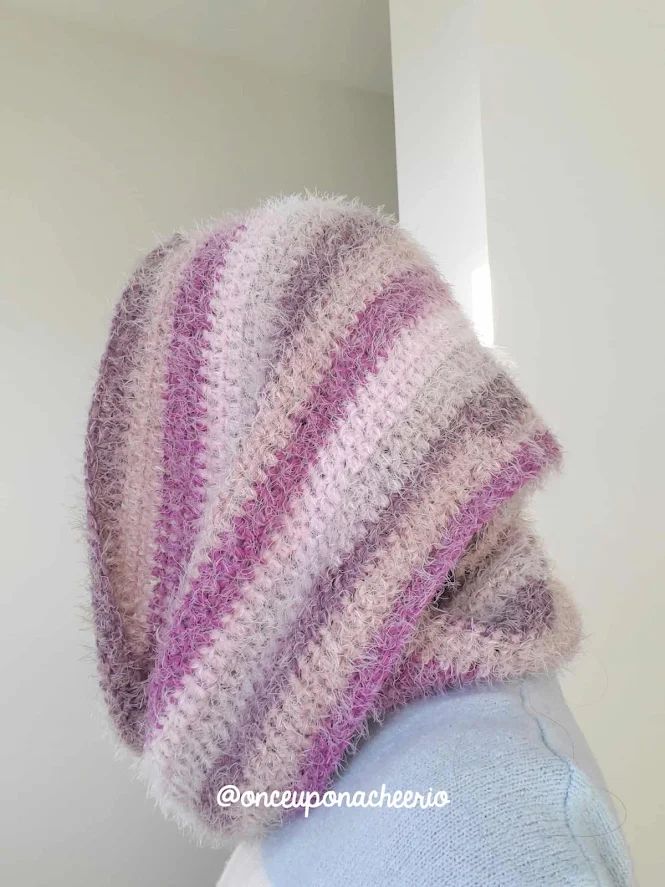 a person wearing a knitted hat with pink and white stripes