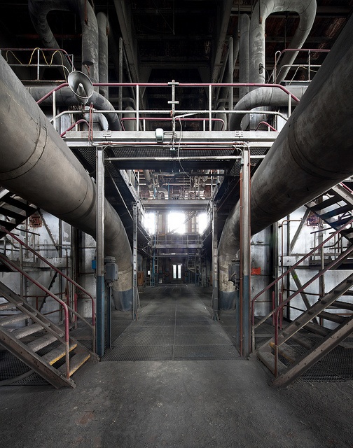 the inside of an industrial building with pipes