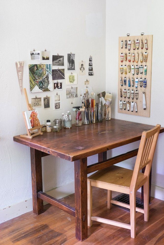 a wooden table with two chairs and pictures on the wall