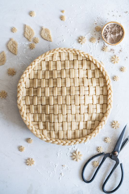 a pie crust sitting on top of a table next to some scissors and other items