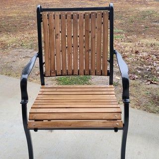 a wooden chair sitting on top of a sidewalk